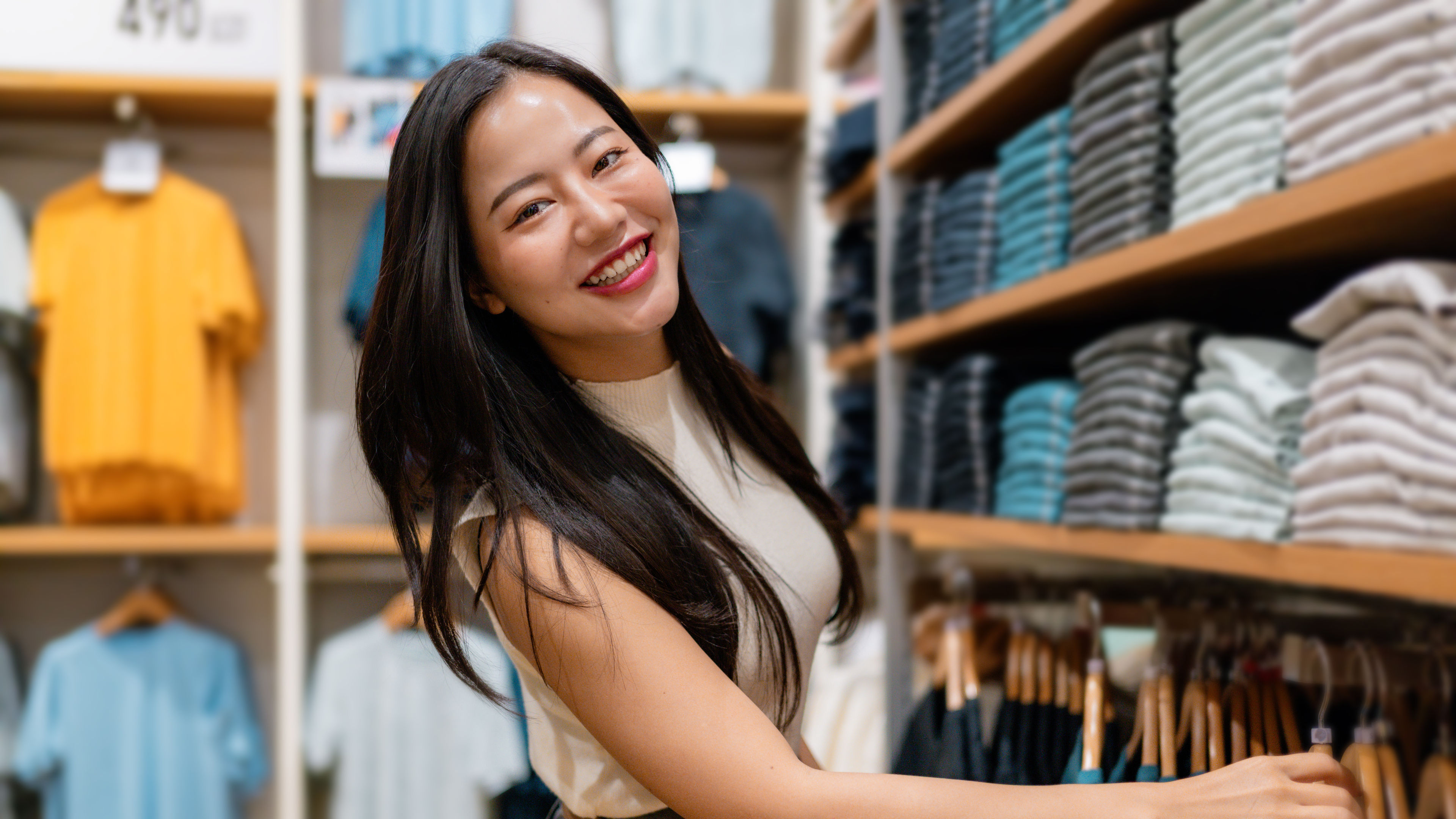 Happy customer smiling and searching clothes in a store.