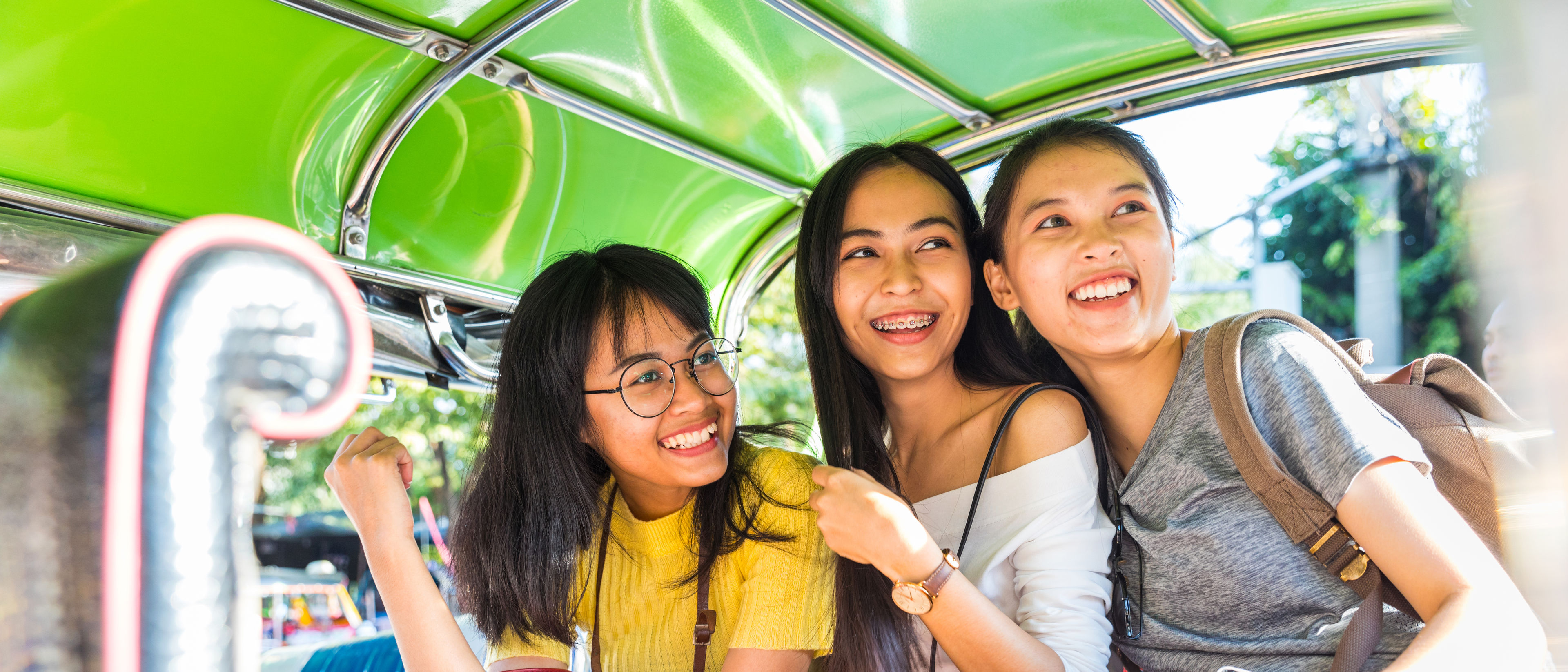 three happy asian girls on a tuk tuk